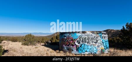 Landscape with graffiti-covered water tank in field, Golden, New Mexico. Stock Photo