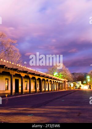 View along Palace Avenue, Santa Fe, New Mexico, past the Palace of the Governors looking towards the Sangre de Christo Mountains with dramatic sky at Stock Photo