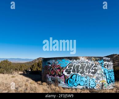 Landscape with graffiti-covered water tank in field, Golden, New Mexico. Stock Photo