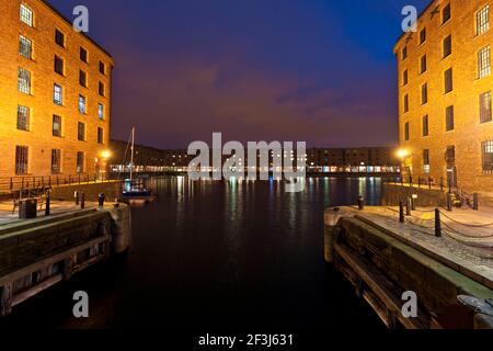 Night view of Albert Dock basin, Liverpool, with lights reflected in the water.  The Albert Dock has England's highest concentration of Grade i Listed Stock Photo