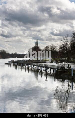 View of weir and sluice gates on the River Thames at Teddington Lock, the tidal limit of the River Thames, with a dramatic dark cloudy sky. Stock Photo