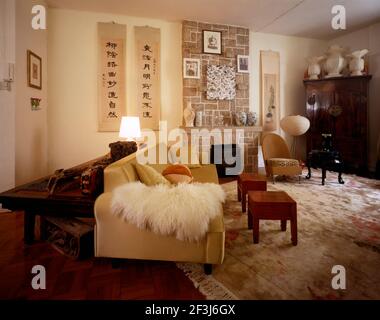 Living room of a modern Chinese apartment featuring a mix of cultural styles  Hong Kong, China. A 1940s chair is covered with leopard skin print fabri Stock Photo