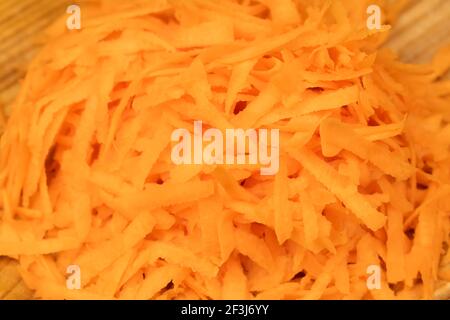Grated fresh carrots on a plate background, macro Stock Photo