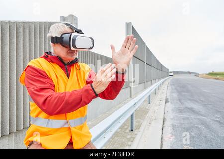 Architect on a road construction site uses VR glasses for virtual construction planning Stock Photo