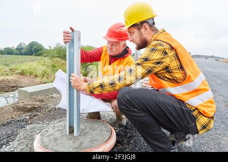 Construction workers check the construction and foundation on the road construction site Stock Photo