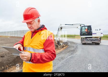 Construction worker using tablet computer during construction planning for house building or road construction Stock Photo