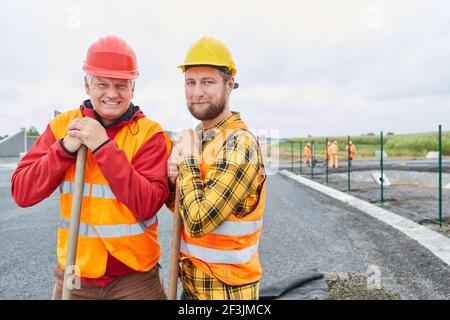 Two workers as road builders on the construction site of the road construction for the bypass Stock Photo
