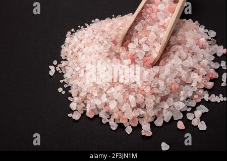 Pink himalayan salt. Himalayan Pink Rock Salt In wooden Spoon on black background. top view. High Angle View Of Himalayan Salt With Wooden Spoon On Ta Stock Photo