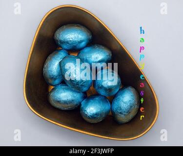 Easter chocolate eggs in the lacquer bowl with Happy Easter message Stock Photo