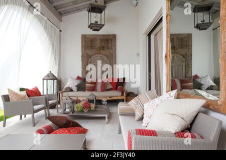 White curtains billowing on Moroccan styled veranda, with colourful cushions arranged on contemporary furniture . Belleview Villa, St Tropez. Stock Photo