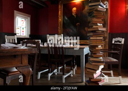 Corner of pub with assorted dining furniture and pillar of books |  | Designer: Richard Brett / We Like Today Stock Photo