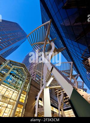 View looking up through steel tree sculptures on Stephen Avenue, Calgary, to the two towers of the Bankers Hall Development at sunrise. Stock Photo