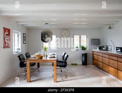 Open plan dining room and kitchen in modernised farm house, Kirke Vaerlose, Copenhagen, Denmark. Stock Photo