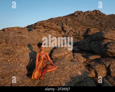 Female with orange silk dress in deep meditating breathing calmly in the  sunset Stock Photo - Alamy
