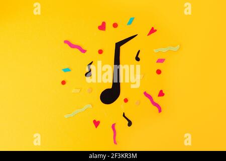 Festival and holiday. A cutted out of felt big note on a yellow background. Flat lay. International Jazz Day. Stock Photo