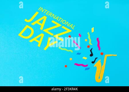 Festival and holiday. A cutted out of felt saxophone on a blue background. Flat lay. International Jazz Day. Stock Photo