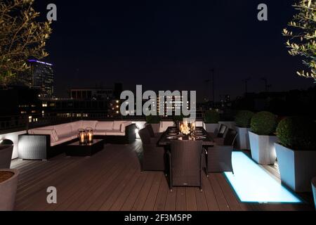 Roof terrace at night with Centre Point tower in the distance in UK show home Stock Photo