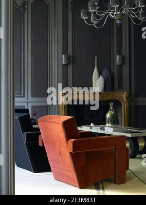 Two armchairs in room with grey wood panels in Paris apartment, France Stock Photo