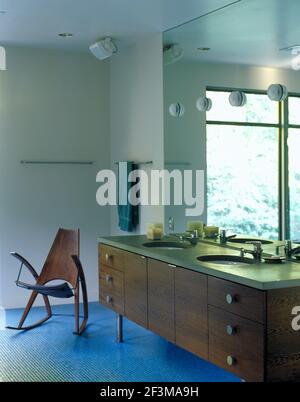Vintage bathroom with double sink, large mirror with mounted lights and chair, USA Stock Photo