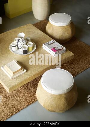 Coffee table with stools with homeware and magazines on top in French villa. Stock Photo
