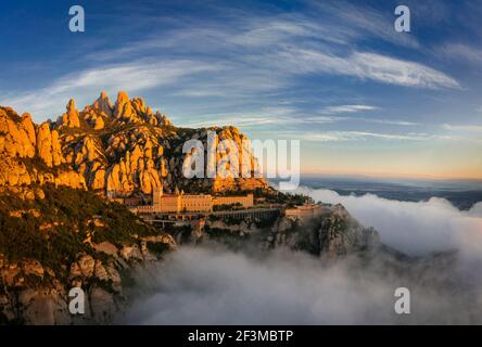 Montserrat and Montserrat Abbey at sunrise with a sea of clouds seen from the Creu de Sant Miquel viewpoint (Barcelona province, Catalonia, Spain) Stock Photo