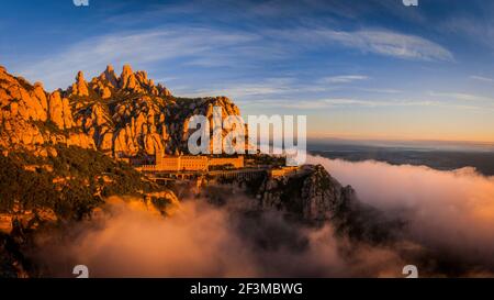 Montserrat and Montserrat Abbey at sunrise with a sea of clouds seen from the Creu de Sant Miquel viewpoint (Barcelona province, Catalonia, Spain) Stock Photo