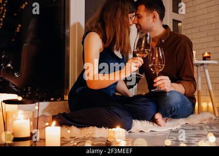 Man and woman having date, sitting on the floor with a lot of burning candles Stock Photo