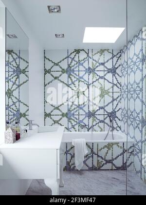 Bathroom with abstract pattern mosaic on two walls and bath panel in residential house, Denmark Stock Photo