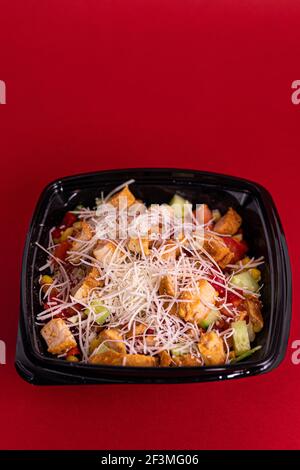 https://l450v.alamy.com/450v/2f3mg06/a-fresh-delicious-salad-with-chicken-pieces-in-a-black-single-use-container-on-the-table-2f3mg06.jpg