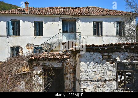 Old traditional stone house with a weathered clay tile rooftop in Psarades, a picturesque rural village at Lake Prespa in West Macedonia Greece. Stock Photo