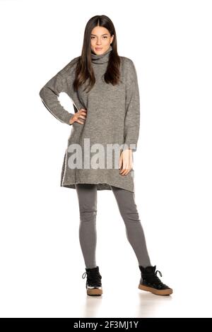 Young beautiful woman in gray tunic on white background