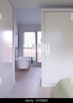 En suite freestanding bath in bedroom of UK home. Stock Photo