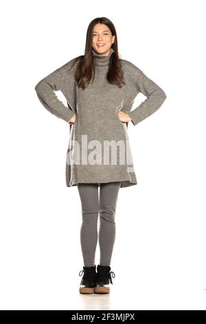 Young beautiful happy woman in gray tunic on white background
