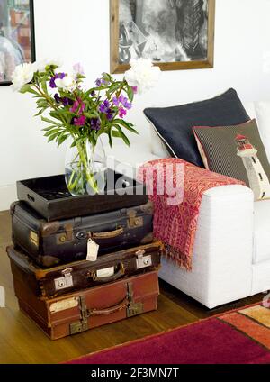 Vase of flowers on stack of old suitcases in UK home Stock Photo