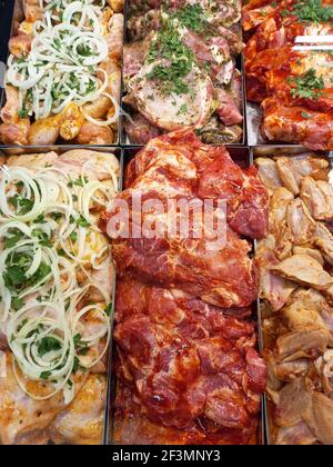 Fresh, marinated meat for barbecue. Appetizing kebabs, raw meat, on the counter in the store. Stock Photo