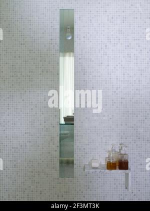Mirror inset in tiled wall in bathroom in USA home Stock Photo
