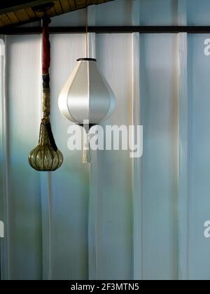 Pendant light seen against painted wood wall in USA home Stock Photo