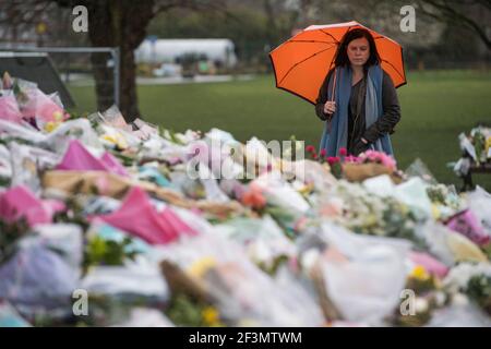 A woman looks at floral tributes left next to the bandstand in Clapham Common, London, for Sarah Everard. Pc Wayne Couzens, 48, appeared at the Old Bailey in London charged with the kidnap and murder of the 33-year-old. Picture date: Tuesday March 16, 2021.