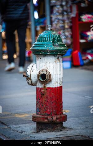 A colourful Fire Hydrant, painted in Italian flag colours, outside a store in 'Little Italy', Manhattan, New York Stock Photo