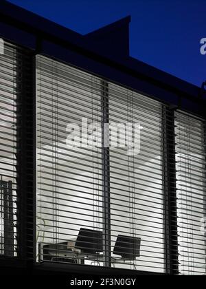Exterior of modern house with view through window with venetian blinds, Australia Stock Photo