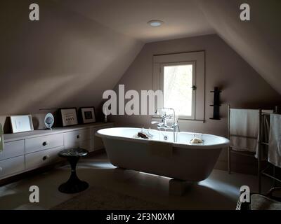 Freestanding bathtub in attic bathroom in USA home Stock Photo