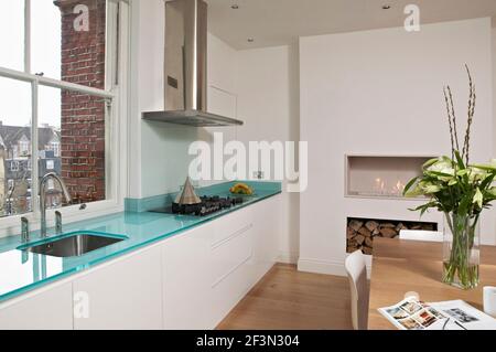 Dining table and chairs in centre of open plan kitchen Stock Photo