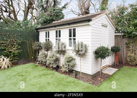 Large family home in Wandsworth, with basement and open plan kitchen extension. Garden with painted wood home office studio Stock Photo