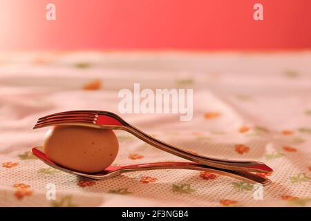 plastic forks with egg on a red background Stock Photo