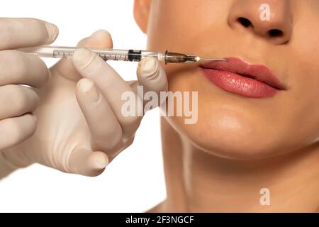 Portrait of a young beautiful woman on a lip filler injection procedure on white background Stock Photo