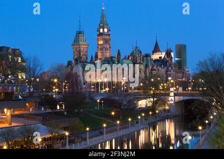 Canada,  Ontario, Ottawa, Parliament Buildings of Canada  illuminated at dusk and the Rideau Canal Stock Photo