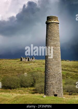 DARTMOOR, Devon. Remains of the Powder Mills at Postbridge, with chimney in the foreground, against an overcast sky. Stock Photo