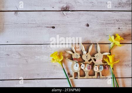 Wooden Easter bunnies with decoration and the text Easter written on eggs. Stock Photo