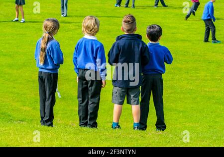 Primary schoolchildren playing in a school playground in a break between classroom lessons. Stock Photo