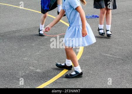 Primary schoolchildren playing in a school playground in a break between classroom lessons. Stock Photo